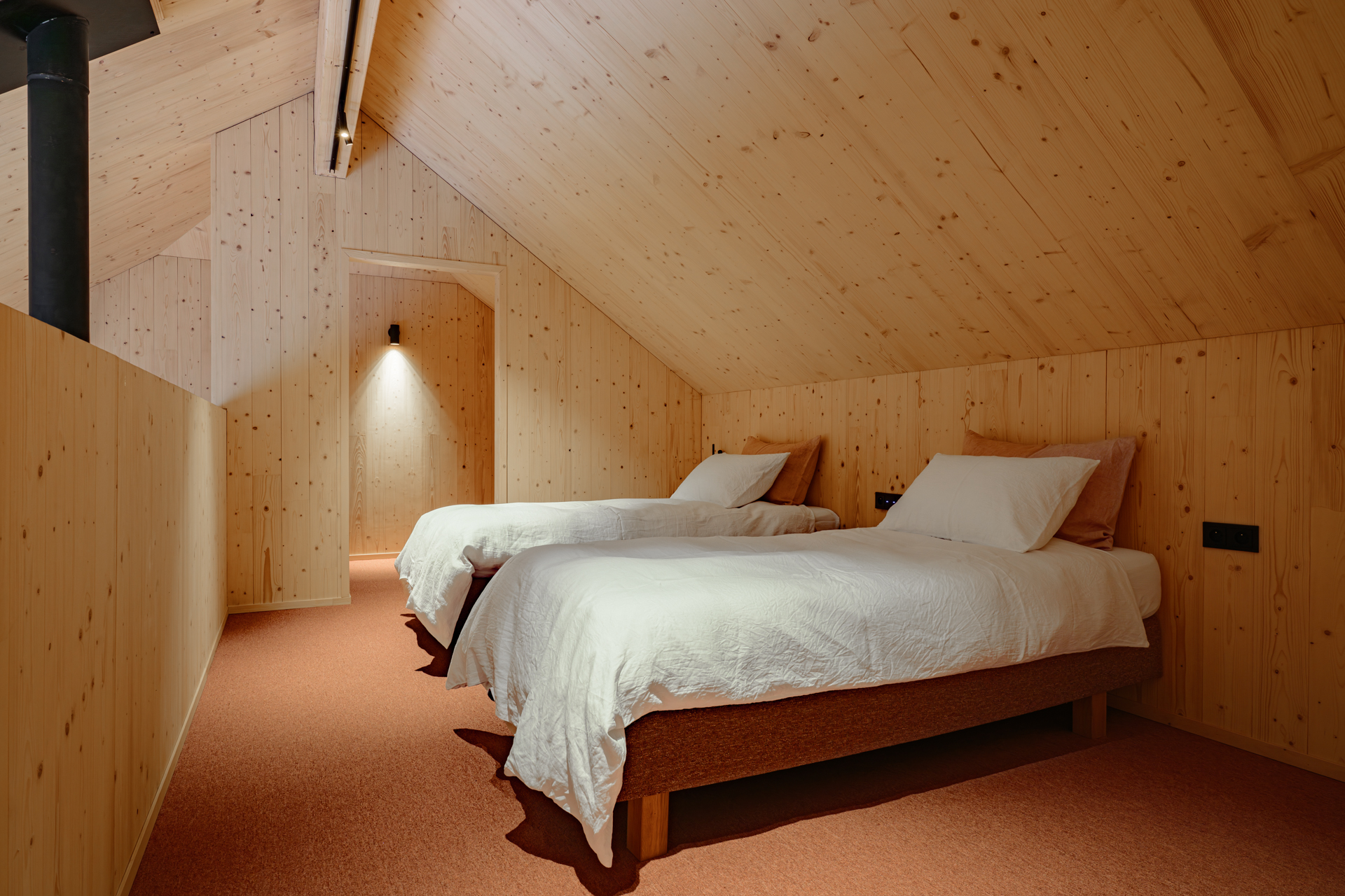 Chambre mansardée en bois avec deux lits simples