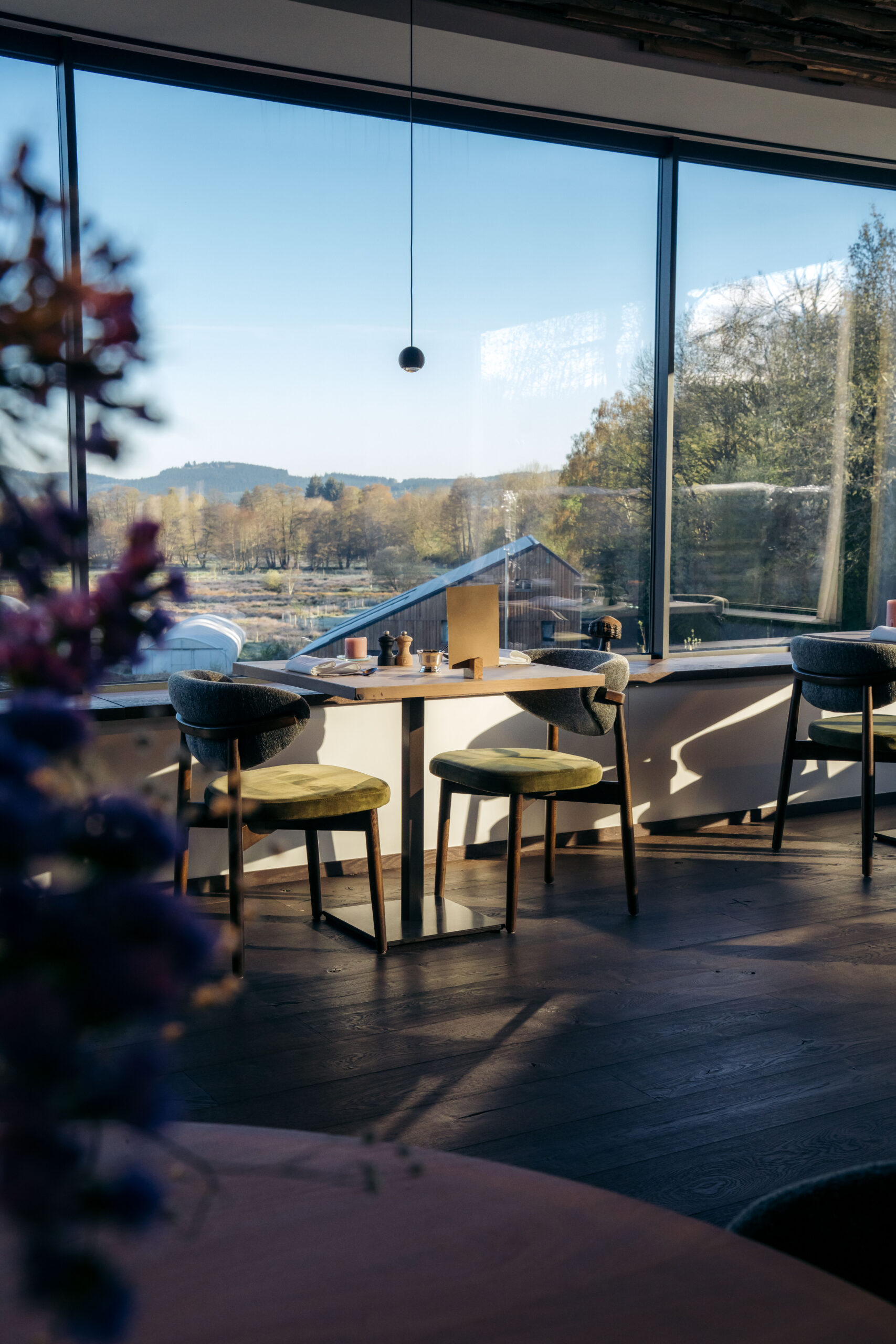 Table du restaurant devant les baies vitrées avec vue sur la vallée